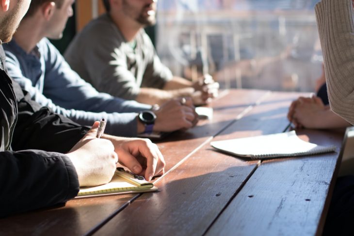 People chatting over a wooden table